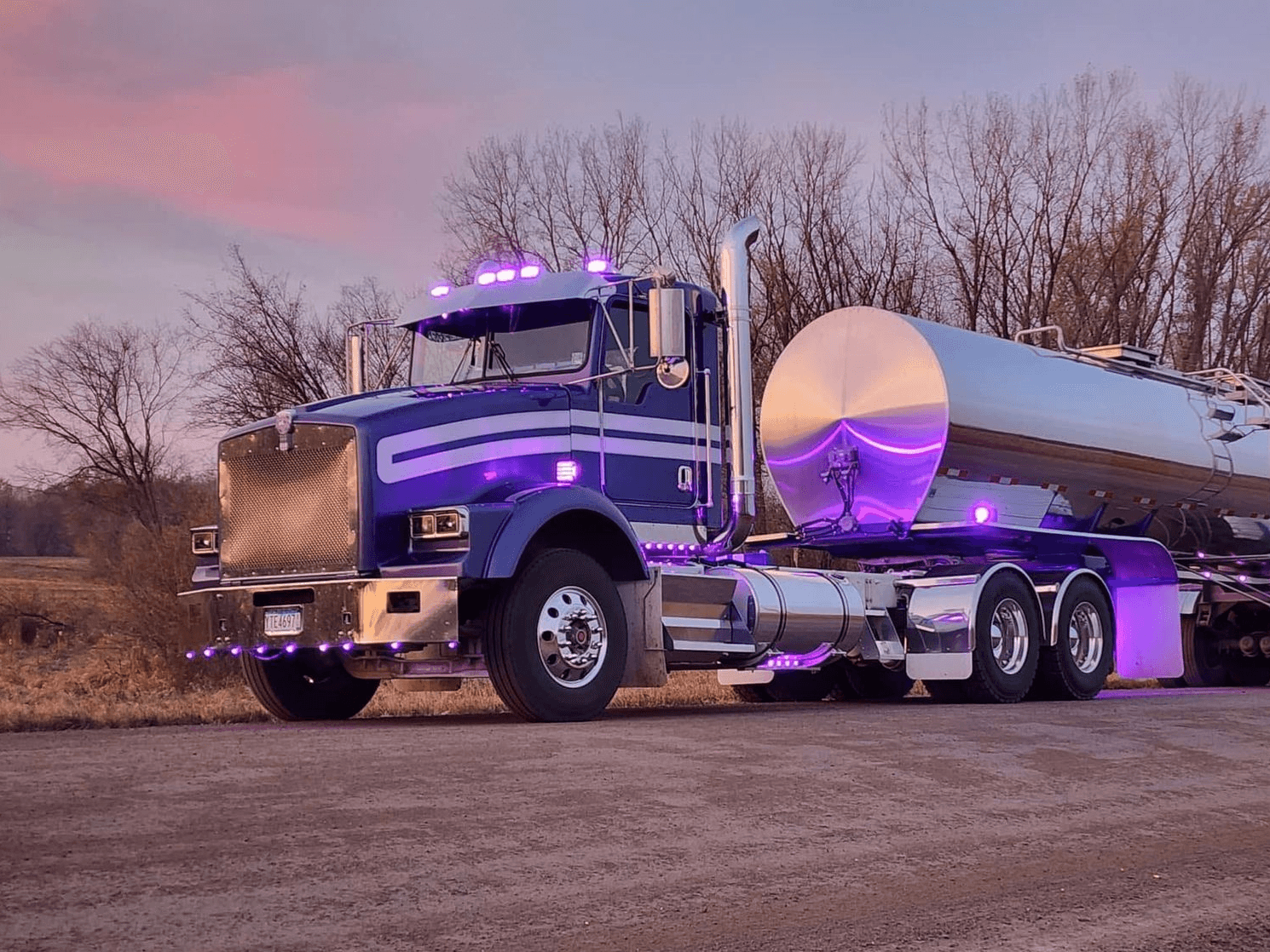 Elite Transport Group milk tanker truck parked at a dairy facility at dusk